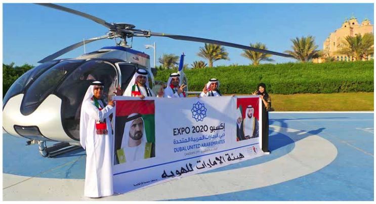 Employees from Emirates ID fly in Dubai’s skies carrying “Expo 2020” Logo